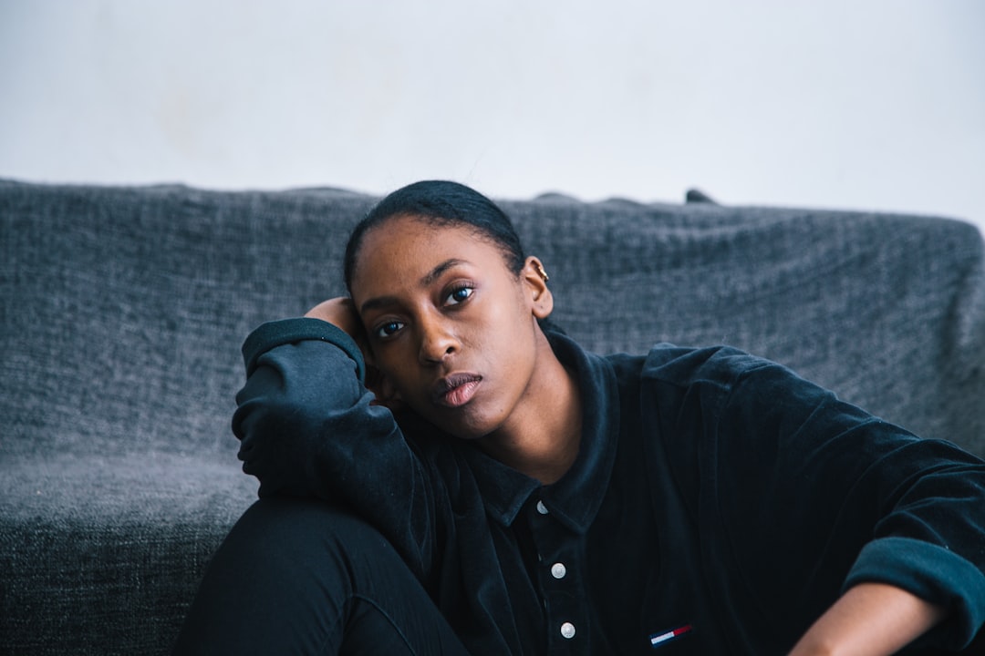 Pensive Black woman resting head on hand, reflecting on her well-being needs