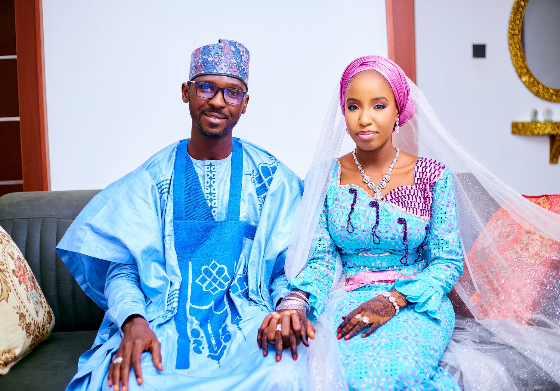Smiling couple wearing traditional attire, holding hands at their wedding ceremony