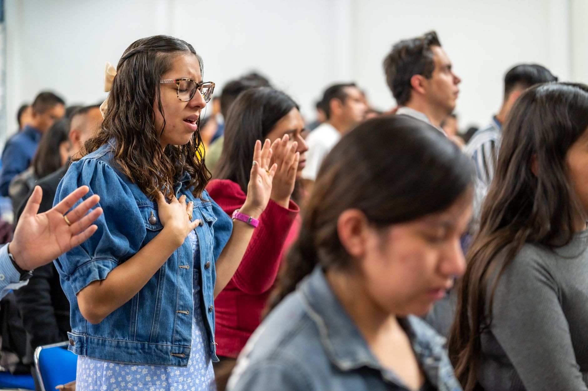 People praying and worshipping with hands raised during a religious ceremony