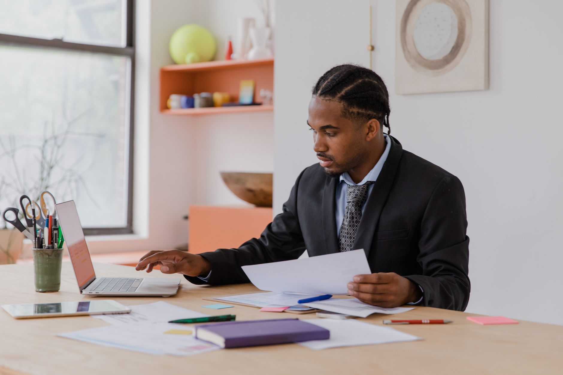 Man in suit reviews documents at a desk, making pre-registration decisions for a company