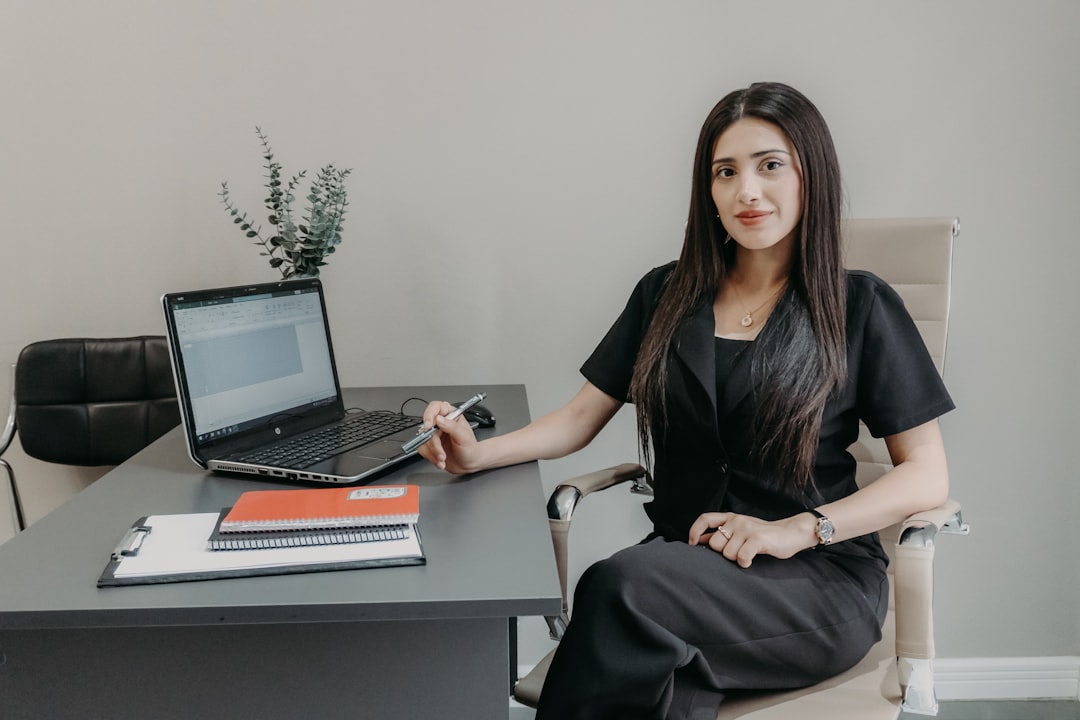 Professional woman therapist sitting at a desk with a laptop, creating an online presence