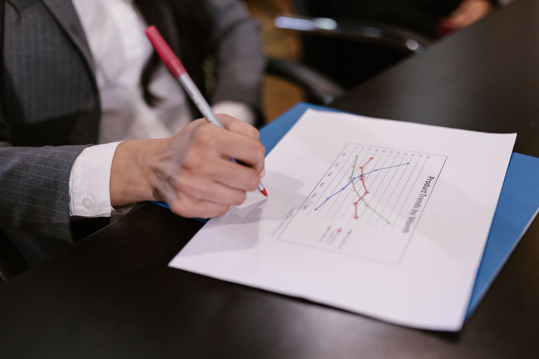 Hand marking a product trends chart with a pen for keyword analysis