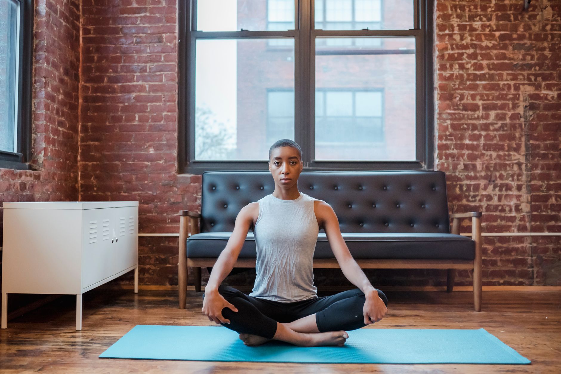 Young woman meditates on a blue mat, promoting well-being and self-trust practices