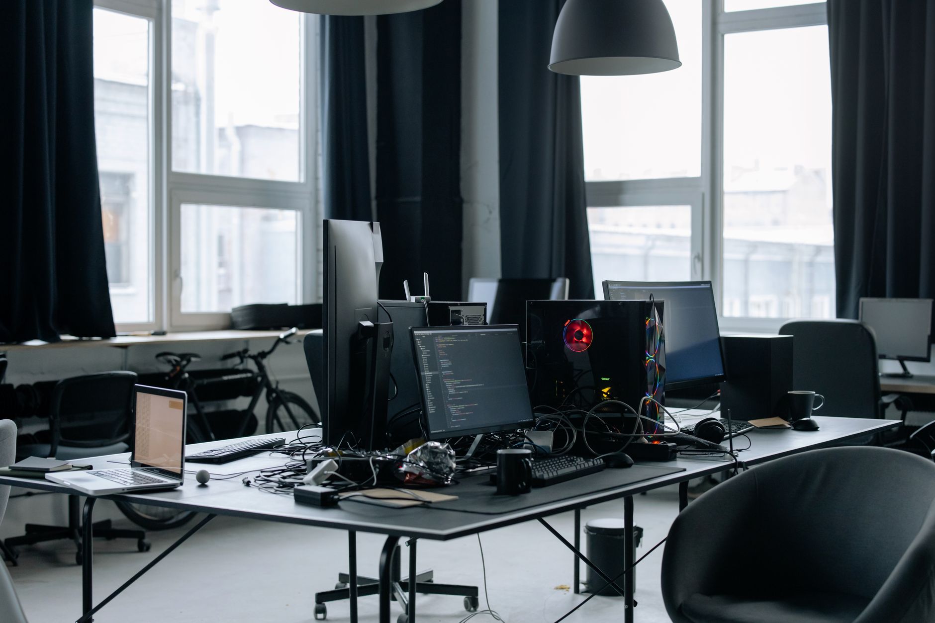 A messy office desk with computers, monitors, and a laptop, for digital work