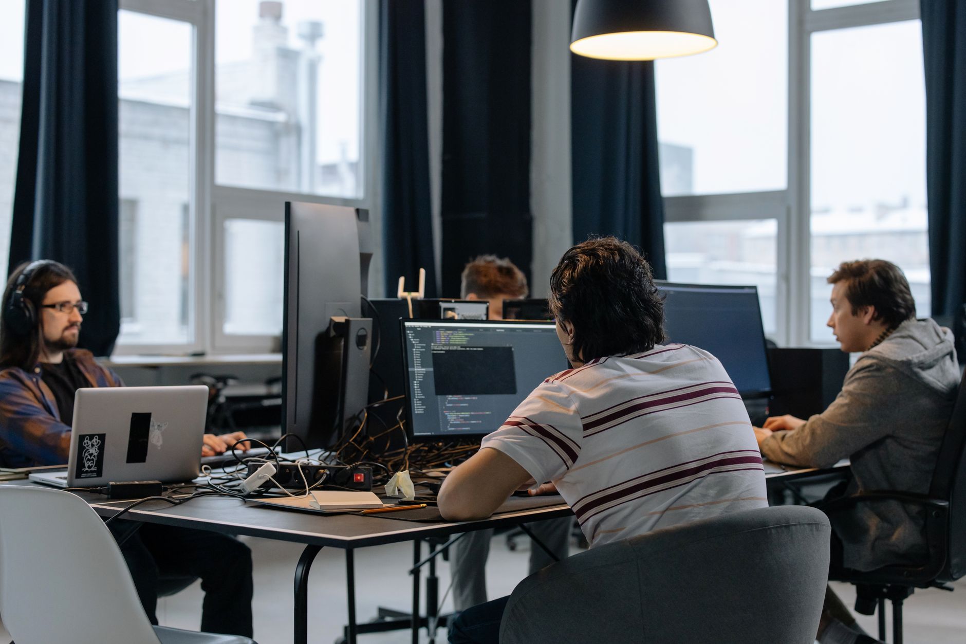 Developers coding at computers in an office, focusing on screens