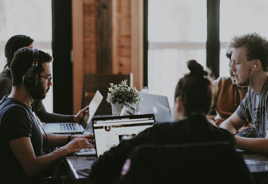 Team of focused professionals working on laptops, defining SEO goals collaboratively