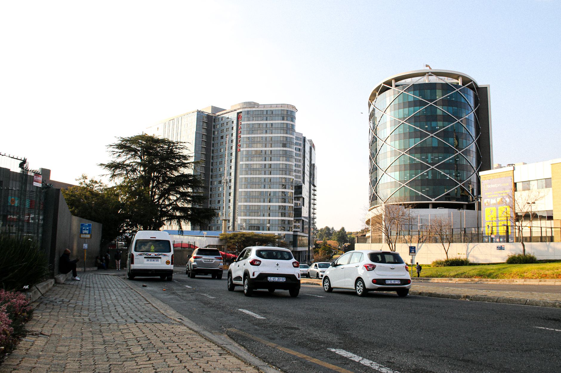 Modern buildings, cars, and people on a city street in an African urban landscape