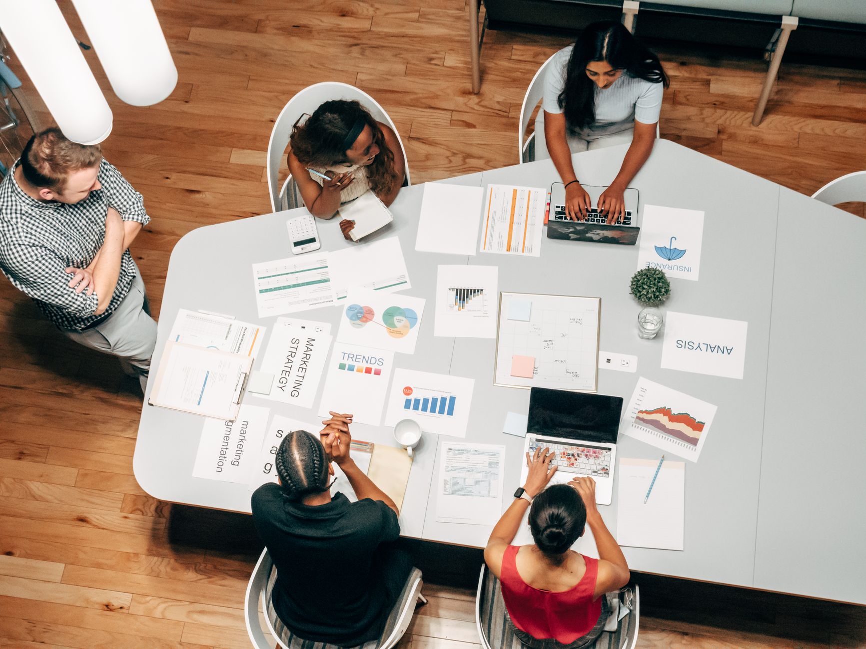 An overhead view of a diverse team collaborating on marketing strategy and analysis