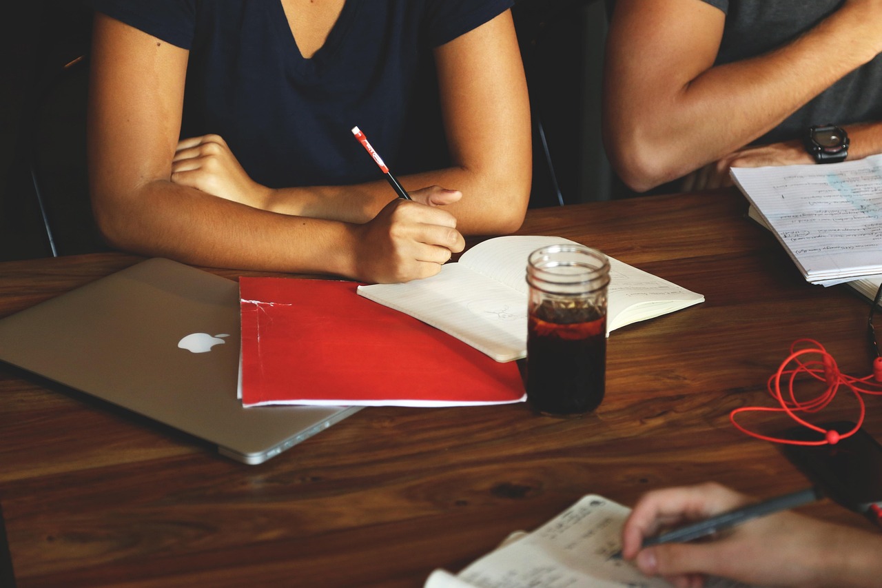 People collaborating at a table with laptops and notebooks planning website development