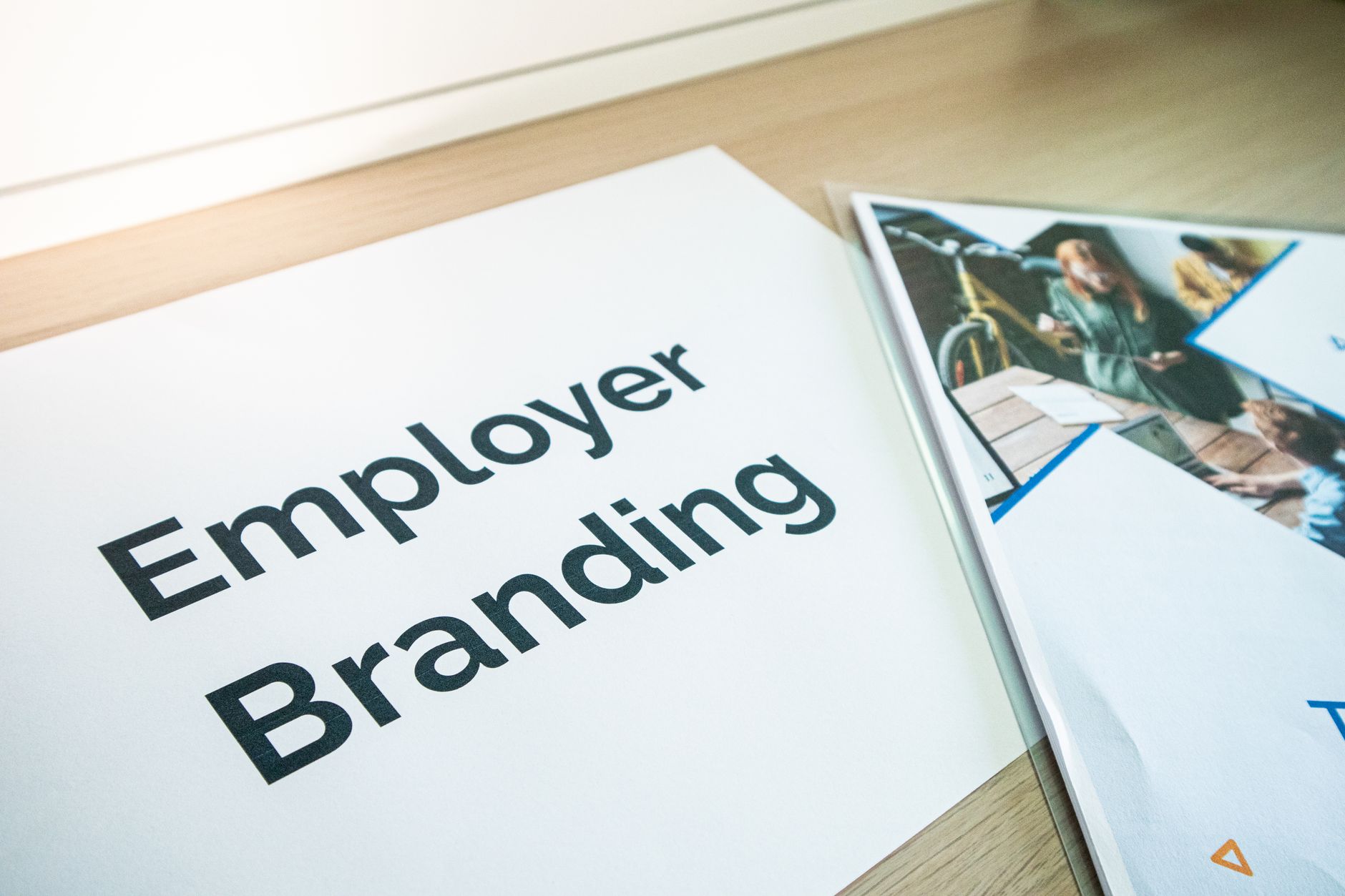 Document with "Employer Branding" text next to a brochure with people images