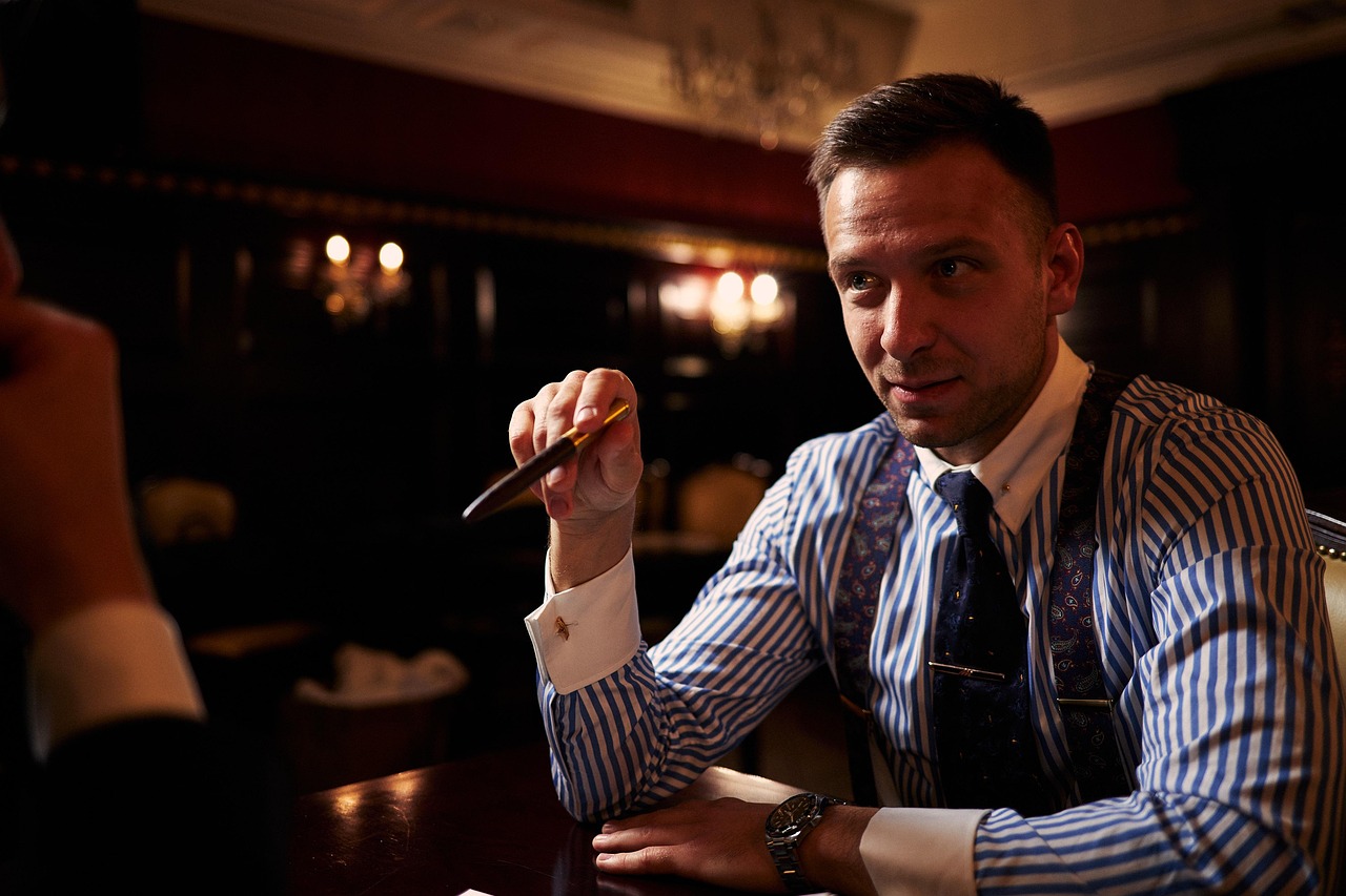 A man in a striped shirt and tie holds a pen, discussing tenant rights
