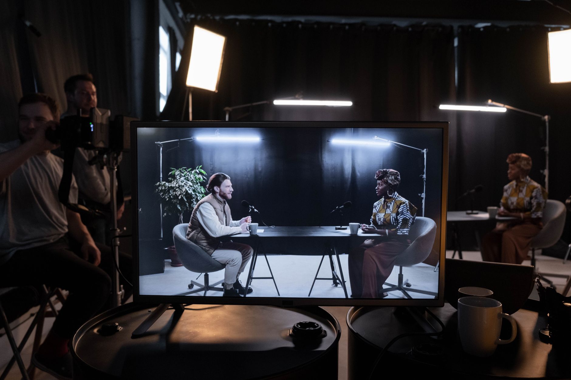 Camera crew filming a video podcast interview displayed on a production monitor