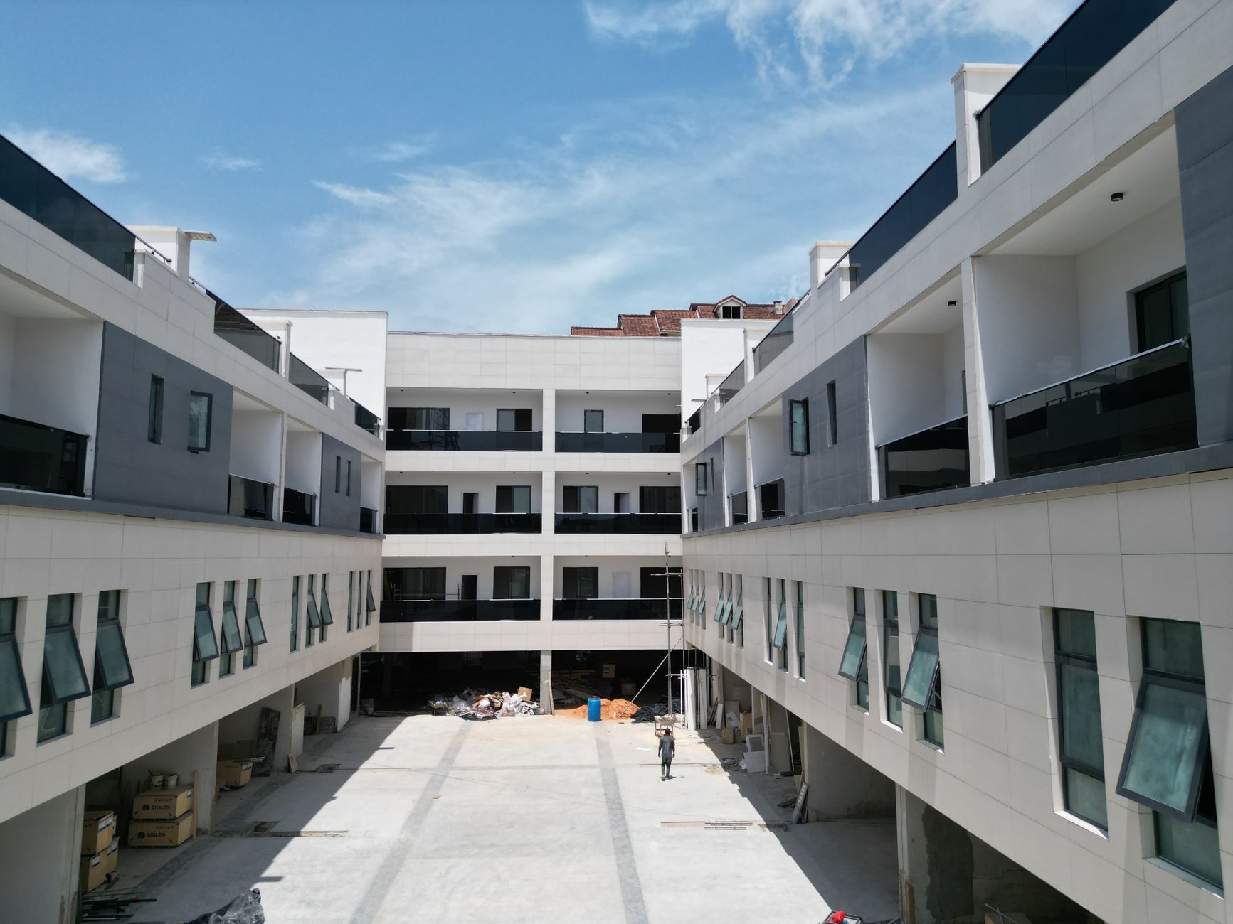 Newly constructed multi-story real estate investment property surrounding a paved courtyard