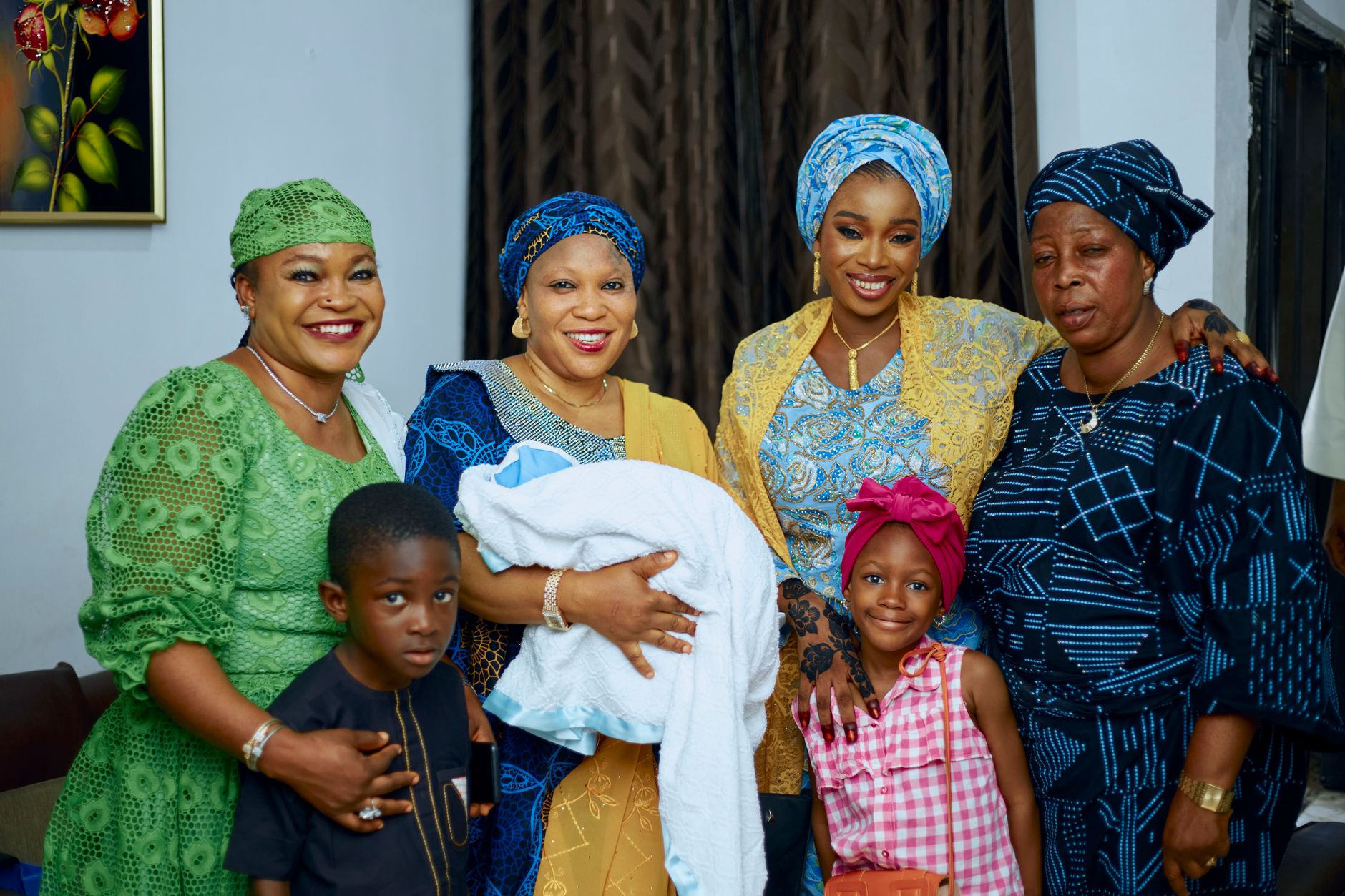 Women and children, including a baby, gathered happily for a naming ceremony