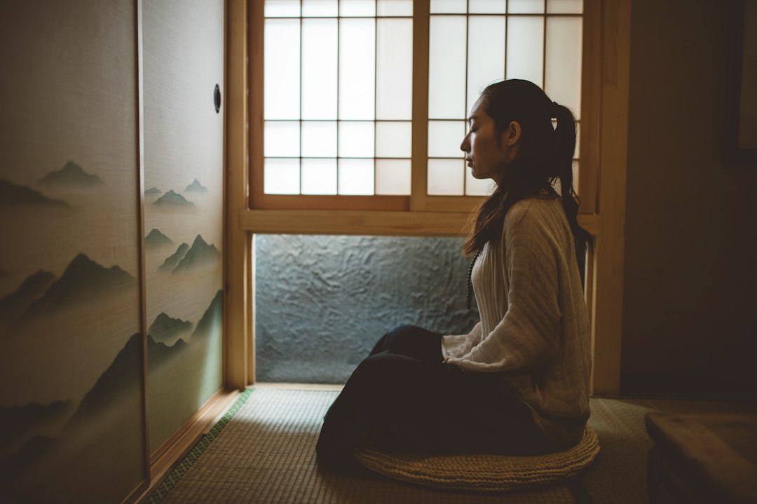 A person meditates on a cushion in a quiet room for inner peace and healing