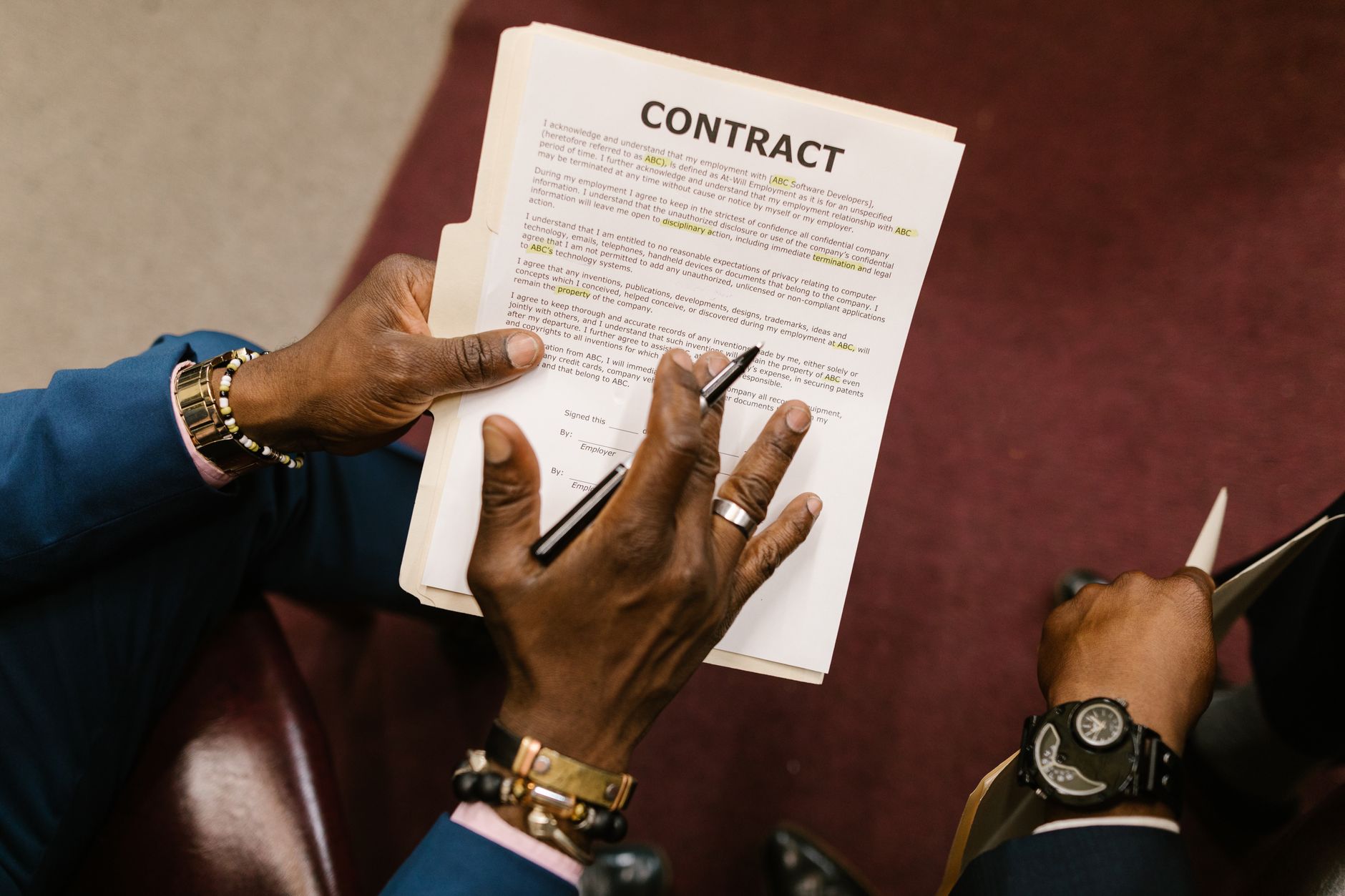 Hands holding a contract document, pointing at text, illustrating agreement signing
