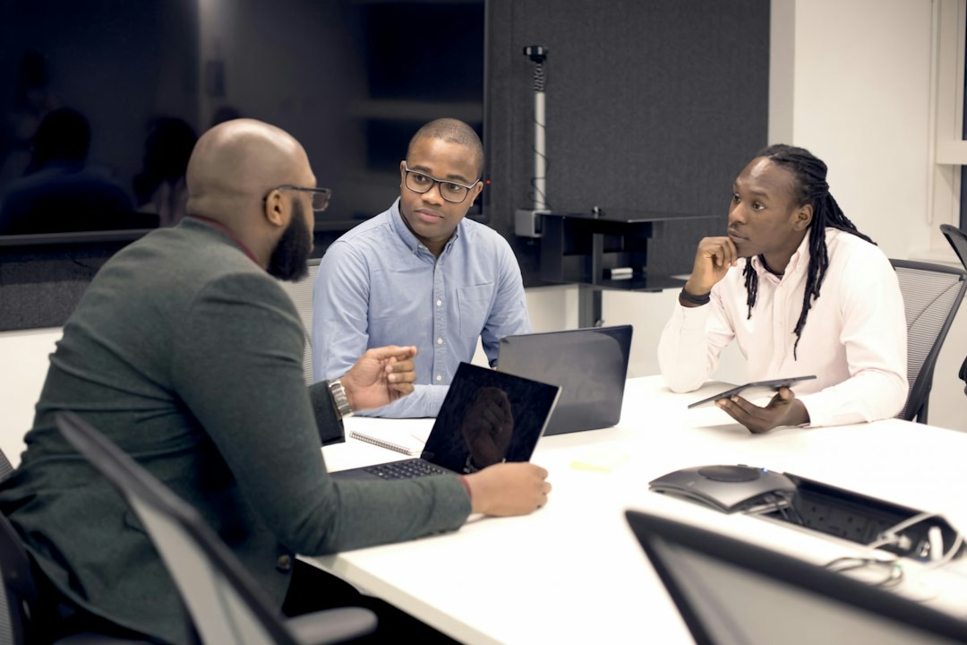 Three men in a modern meeting room discussing legal lease agreements