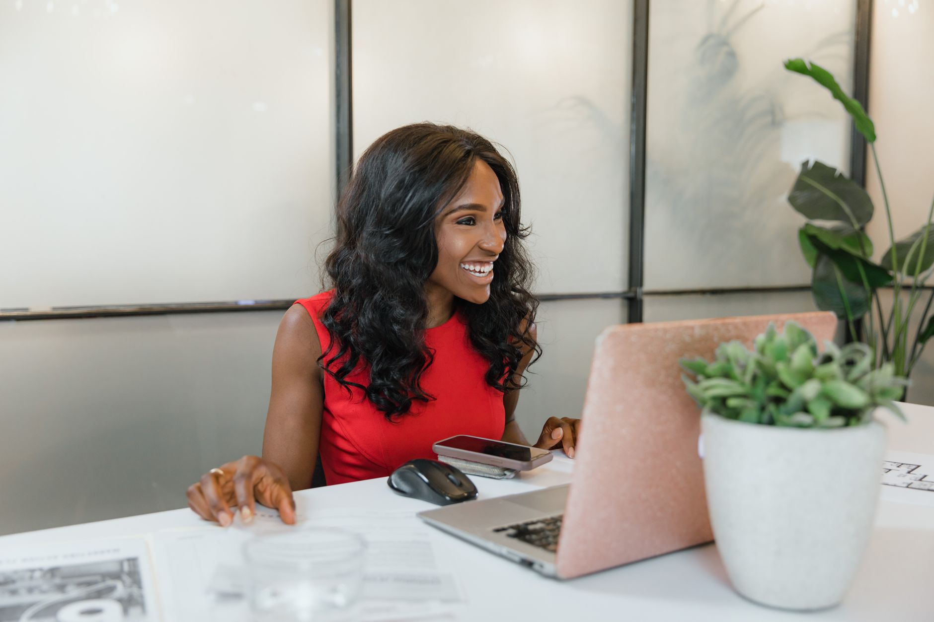 Smiling woman looking at her laptop, using software for on-page SEO analysis