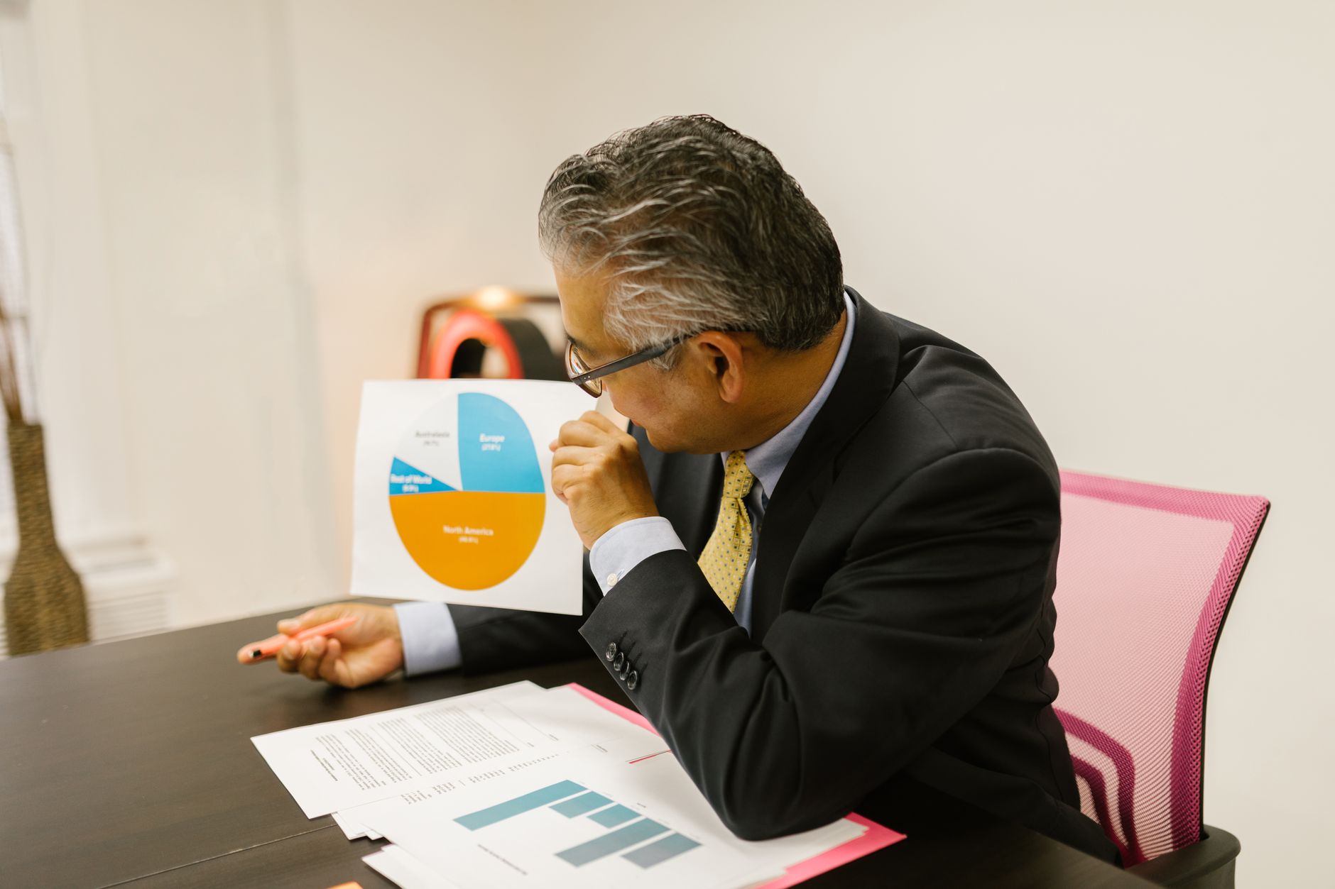 Man in a suit studies a pie chart representing global data distribution