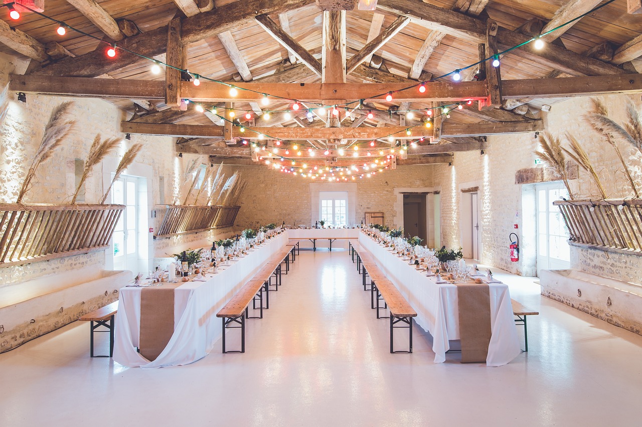 Rustic barn venue set with long tables, benches, and string lights for a party