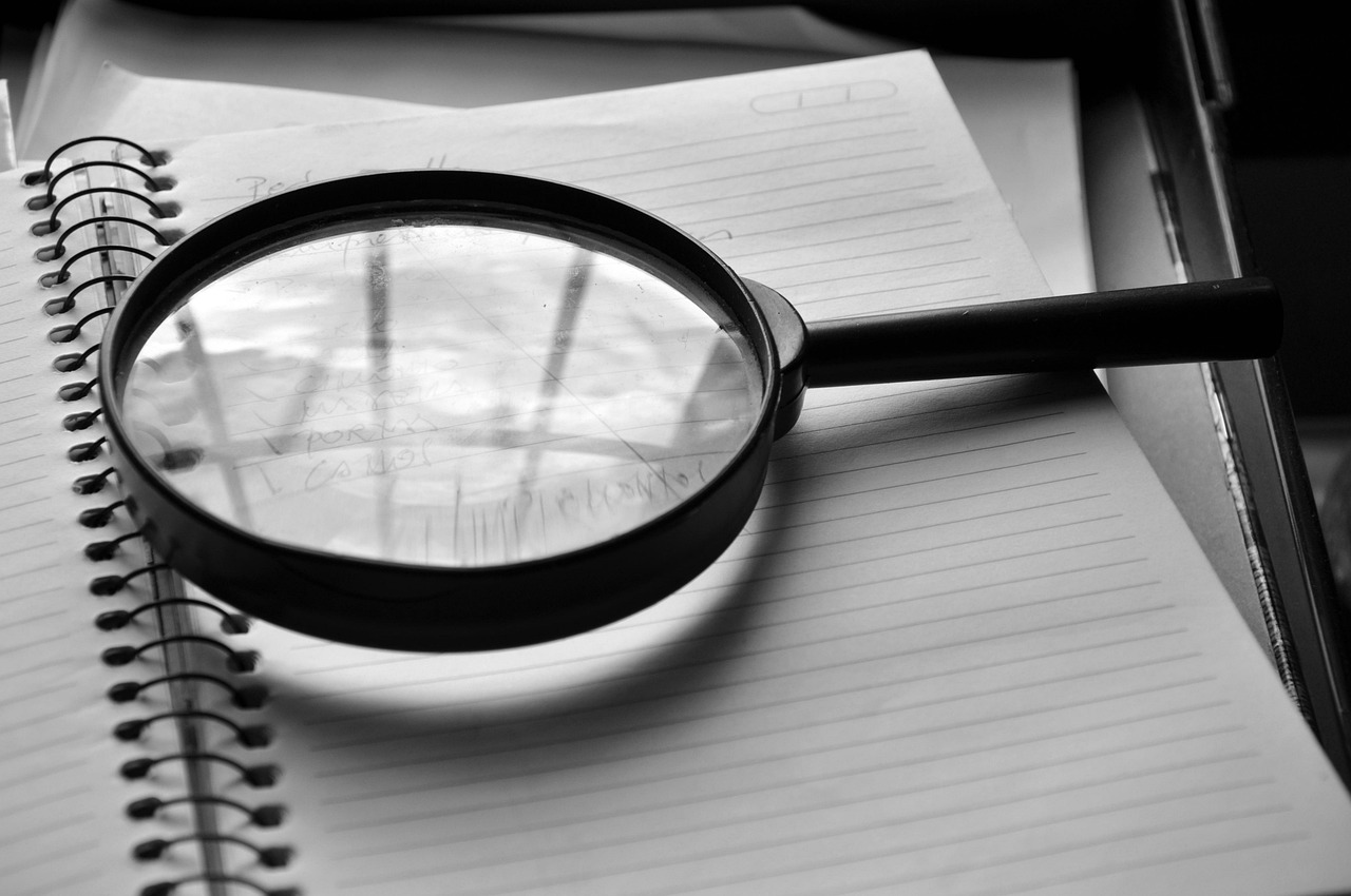 Magnifying glass resting on a notebook, symbolizing a technical SEO audit investigation